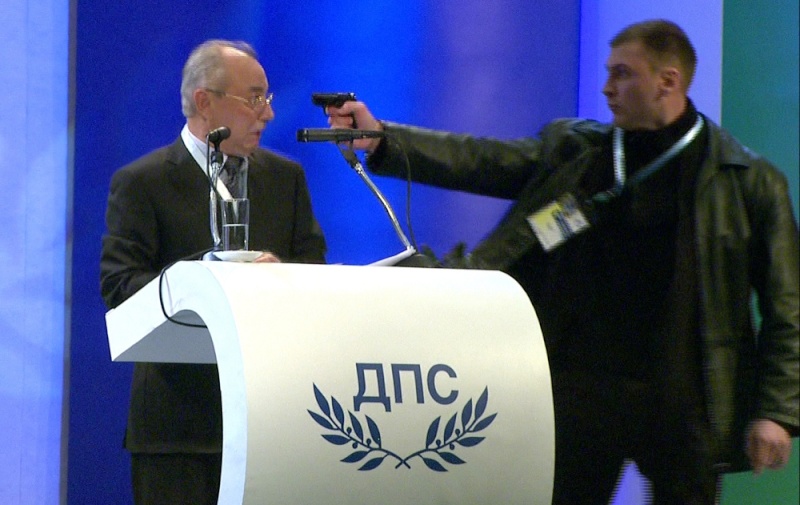 Político búlgaro es amenazado con una pistola durante un discurso Ay_10110