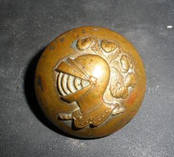 Botón con casco tocado con plumas. 1178