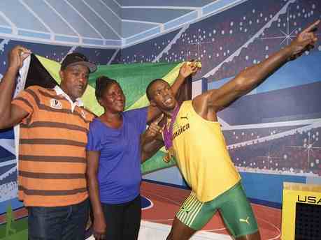 usain bolt's father and mother pose beside a waxed figure of their son Boltwa10