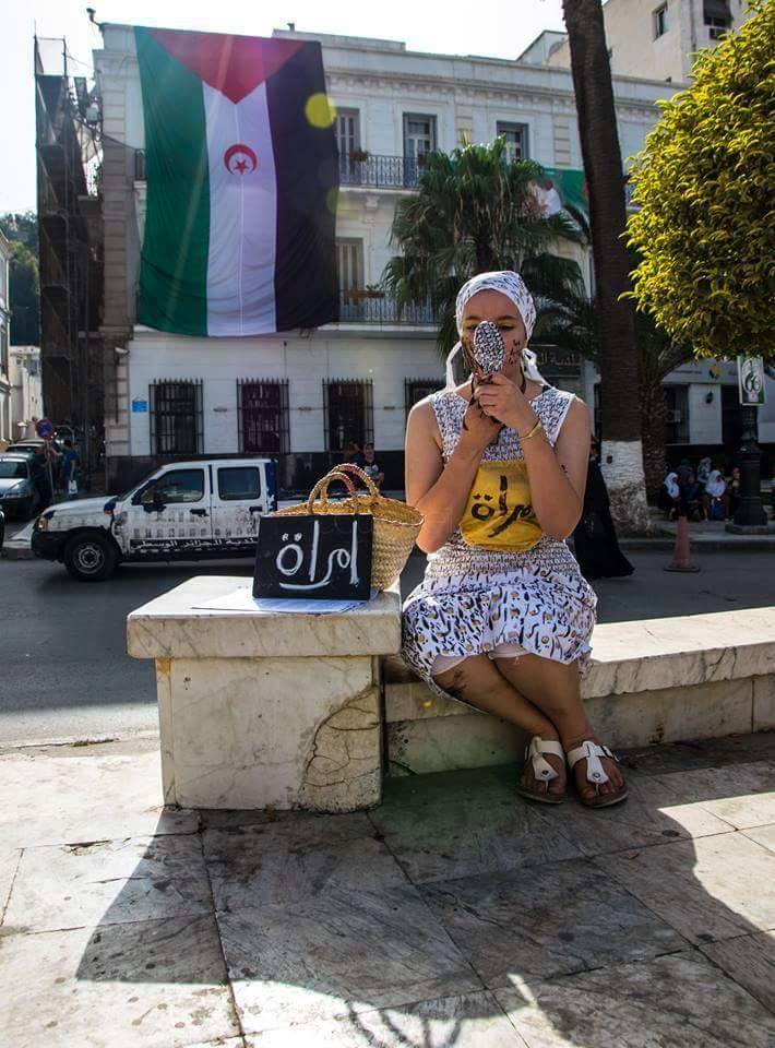 Cette jeune femme sillonne les rues d'Alger en écrivant un peu par tout le mot femme  213