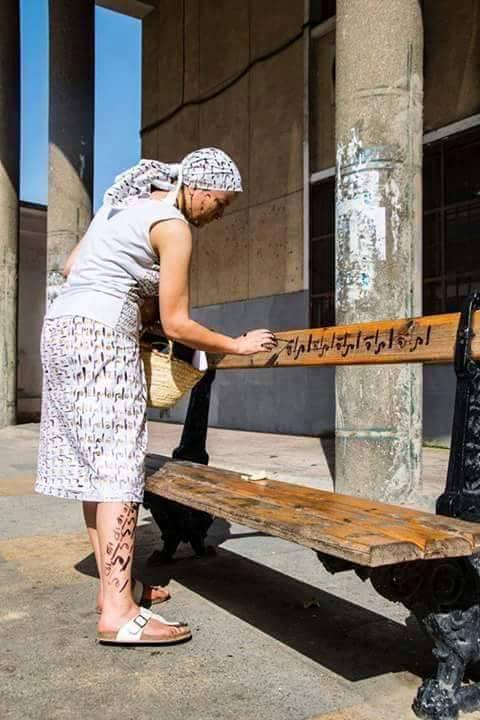 Cette jeune femme sillonne les rues d'Alger en écrivant un peu par tout le mot femme  217