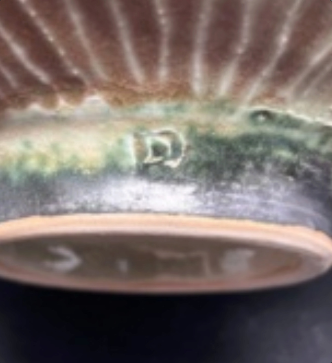 ID of maker of bowl possibly a D mark or R mark which is full of glaze Dmark110
