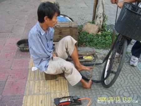 A man fixing tyres with his feet Pic310