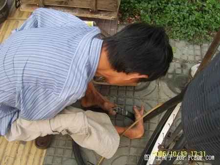 A man fixing tyres with his feet Pic410