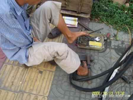 A man fixing tyres with his feet Pic510