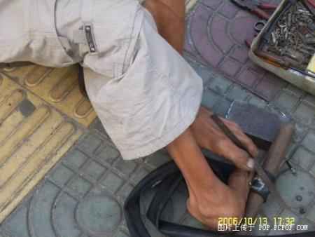 A man fixing tyres with his feet Pic610