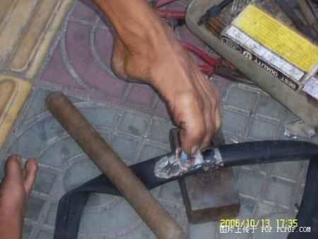 A man fixing tyres with his feet Pic910