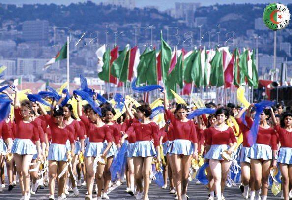 Algérie 1967 Après l’indépendance : parade de jeunes filles en tenue de majorettes, tambourins, foulards et drapeaux levés 1291